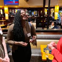 Three alums laughing together.